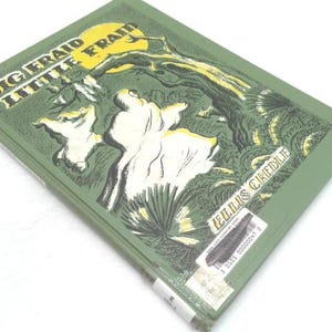 May include: Vintage book titled "Big Fraid Little Fraid" by Ellis Credle. The cover features a green background with a yellow moon and white figures. The book has a sticker on the bottom right corner.