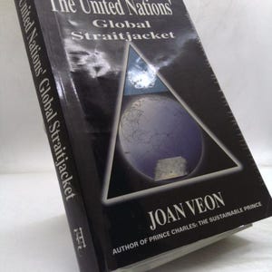 May include: A hardcover book titled "The United Nations' Global Straitjacket" by Joan Veon. The cover is black with a triangular design featuring a globe and a moon. The book's spine also displays the title.