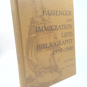 May include: A hardcover book titled "Passenger and Immigration Lists Bibliography 1538-1900." The cover is tan with a sepia-toned illustration of a sailing ship. The book's spine also features the title. The second edition is edited by P. William Filby.
