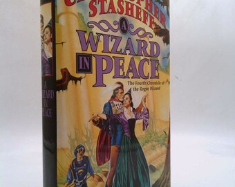 May include: A book cover with a colorful illustration of a wizard and a woman in a forest setting. The title of the book is "A Wizard in Peace" and the author is Christopher Stasheff. The book is part of a series called "The Fourth Chronicle of the Rogue Wizard".