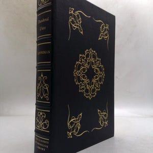 May include: A hardcover book with a black cover and gold decorative accents. The spine reads "Duodenal Ulcer" and "MOYNIHAN". The cover features ornate gold designs. The book is part of "THE CLASSICS OF MEDICINE LIBRARY".