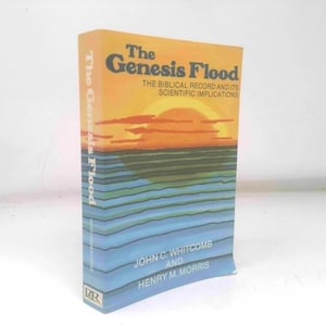 May include: A hardcover book titled "The Genesis Flood" with a colorful cover. The cover features a sunset over water, with the title in large, bold letters. The book's spine also displays the title. The authors are John C. Whitcomb and Henry M. Morris.