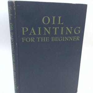 May include: A hardcover book titled "OIL PAINTING FOR THE BEGINNER" in green lettering on a dark blue background. The book's spine reads "Taubes OIL PAINTING FOR THE BEGINNER". The book is standing upright.