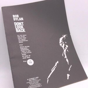 May include: A vintage Bob Dylan "Don't Look Back" music sheet. The cover is dark gray with white text and a silhouette of a person. The text includes song titles and the price of $3.50.