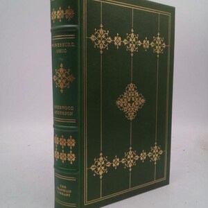 May include: A hardcover book with a dark green cover and gold decorative accents. The spine reads "Winesburg, Ohio" and "Sherwood Anderson." The book is part of "The Franklin Library" collection.