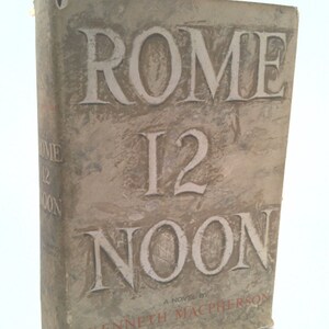 May include: A vintage book cover with the title "ROME 12 NOON" in large, stylized lettering. The cover is a light brown color with a textured surface. The author's name, "KENNETH MACPHERSON", is printed in smaller lettering below the title.