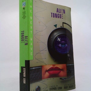 May include: A green and black paperback book titled "Alien Tongue: The Next Wave" by Stephen Leigh with an essay by Rudy Rucker. The cover features a stylized image of a microphone, a woman's lips, and a circuit board.