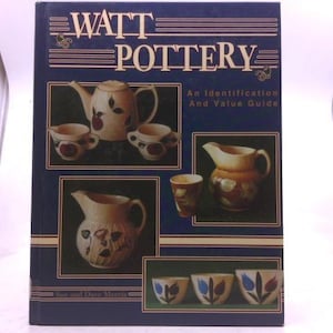 May include: A book titled "Watt Pottery" with images of various pottery pieces. The cover is dark blue with the title in white and gold lettering. The book includes pictures of teapots, pitchers, cups, and bowls.
