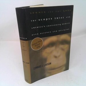 May include: A white ceramic mug with a black handle and the text "But First, Coffee" in a bold, black font. The mug is set against a blurred background, suggesting a cozy setting.