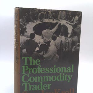 May include: A brown book with a black and white photo of a group of people looking into a hole on the cover. The title of the book is "The Professional Commodity Trader" by Stanley Kroll.