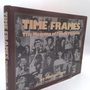 May include: A hardcover book titled "TIME FRAMES" with the subtitle "The Meaning of Family Pictures." The cover features a collage of black and white photographs. The author's name, Michael Lesy, is also visible.