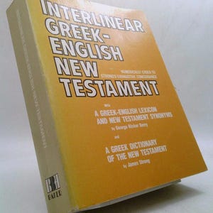 May include: A hardcover book titled "Interlinear Greek-English New Testament" with a yellow and white cover. The book includes text about a Greek-English lexicon and a Greek dictionary of the New Testament.