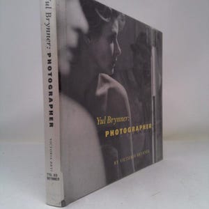 May include: A hardcover book titled "Yul Brynner: Photographer" by Victoria Brynner. The cover features a black and white photograph of a person in profile. The spine displays the title and author's name.