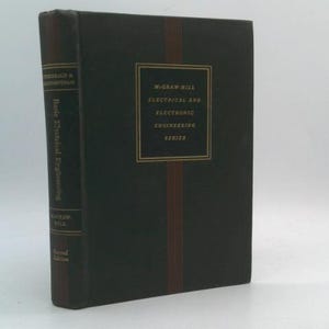 May include: A hardcover book titled "Basic Electrical Engineering" from the McGraw-Hill Electrical and Electronic Engineering Series. The book has a dark cover with gold lettering and a vertical stripe design. The second edition is visible.