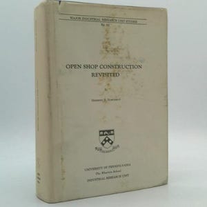 May include: A hardcover book titled "OPEN SHOP CONSTRUCTION REVISITED." The cover is off-white with black text and a university emblem. The book is part of the "MAJOR INDUSTRIAL RESEARCH UNIT STUDIES" series.