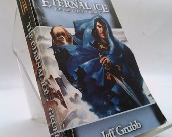 May include: A paperback book titled "Magic: The Gathering The Eternal Ice Ice Age Cycle Book II" by Jeff Grubb. The cover features a blue-robed figure holding a sword and a skull in the background.