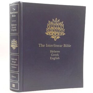 May include: A dark blue hardcover book titled The Interlinear Bible, Hebrew Greek English, featuring a gold embossed tree emblem on the front cover and spine. The spine includes text indicating it is coded with Strong's Concordance Numbers.