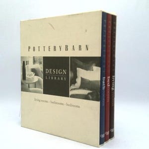 May include: A Pottery Barn Design Library set. The cream-colored box set features the Pottery Barn logo and the words "Design Library" with images of living rooms, bathrooms, and bedrooms. The set includes three books with blue, red, and brown spines.