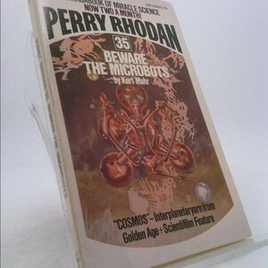 May include: A vintage paperback book titled "Perry Rhodan 35 Beware the Microbots" by Kurt Mahr. The cover features a brown and orange illustration of a robot and the text "COSMOS - Interplanetary yarn from Golden Age + Scientifilm Feature".