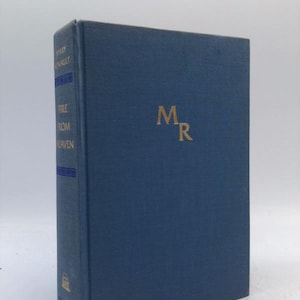 May include: A hardcover book titled "Fire From Heaven" by Mary Renault. The book has a blue cover with gold lettering and the initials "MR". The spine features the author's name and title.
