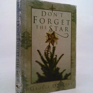 May include: A green book with the title "Don't Forget the Star" and the author's name "George Derrant" on the cover. The cover features a stylized image of a Christmas tree with a star on top.
