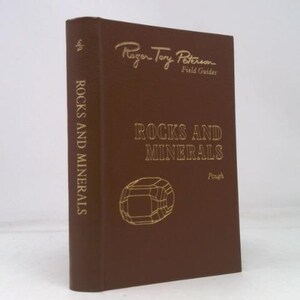 May include: A brown hardcover book titled "Rocks and Minerals" by Roger Tory Peterson. The title and author's name are in gold lettering. The book has a geometric illustration of a mineral on the cover and the spine reads "Rocks and Minerals".