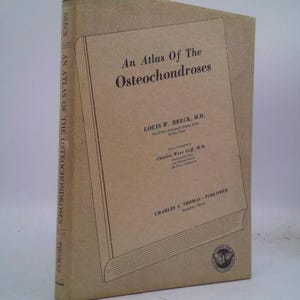 May include: A tan book with the title "An Atlas Of The Osteochondroses" by Louis W. Breck, M.D. The book is published by Charles C Thomas.
