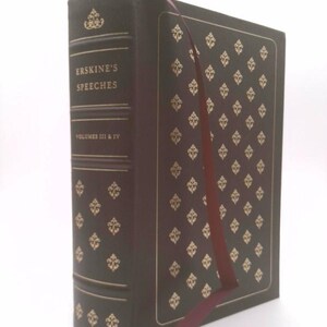 May include: A hardcover book titled "Erskine's Speeches, Volumes III & IV." The dark brown book has gold embossed floral patterns and text. A maroon ribbon bookmark is inserted. The book is on a white background.