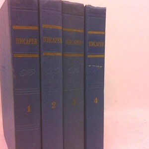 May include: A collection of four blue hardcover books with gold lettering. The spines display the title "Писарев" and volume numbers 1 through 4. The books have a textured appearance.