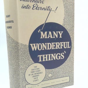 May include: A vintage book titled "Many Wonderful Things." The cover is a light beige with a blue circle containing the title in white. The book's spine reads "Many Wonderful Things." The cover also includes the text "Adventure into Eternity...!"