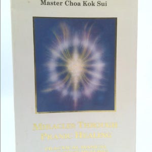 May include: Book cover with a white background and gold lettering. The title is "Miracles Through Pranic Healing: A Practical Manual on Energy Healing" by Master Choa Kok Sui. The cover features a colorful image of a starburst.