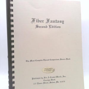 May include: The cover of a book titled "Fiber Fantasy Second Edition" with the subtitle "The Most Complete Thread Comparison Source Book". The book was published by It's A Crewel World, Inc. and is by Carolyn Hook. The book was published at 127 Essex Street, Salem, Ma 01970.