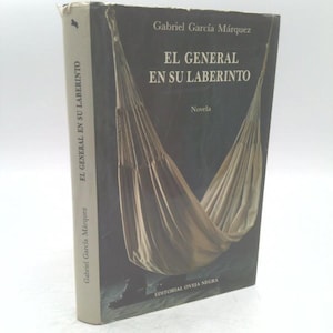 May include: A hardcover book titled "EL GENERAL EN SU LABERINTO" by Gabriel García Márquez. The cover features a dark background with a depiction of a hammock. The book's spine displays the title and author's name.