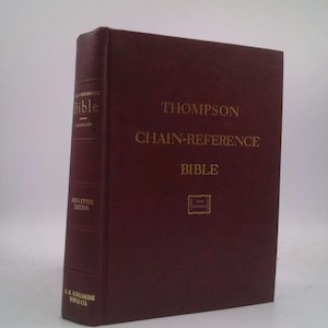 May include: A burgundy Thompson Chain-Reference Bible. The book has gold lettering on the cover and spine, with the words "Red Letter Edition" visible. The book is a hardcover edition.