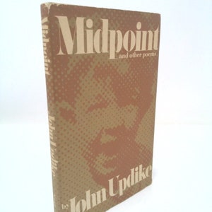 May include: A brown book with the title "Midpoint and other poems" by John Updike. The cover features a brown and white abstract design.