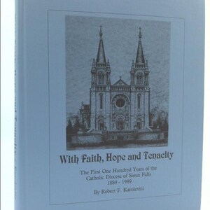 May include: A light blue book titled "With Faith, Hope and Tenacity." The cover features a detailed black and white illustration of a cathedral with two spires. Text on the cover includes the title, the subject matter, and the author's name.