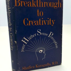 May include: A hardcover book titled "Breakthrough to Creativity" with a dark blue cover and orange lettering. The book features the text "Your Higher Sense Perception" and the author's name, Shafica Karagulla, M.D.