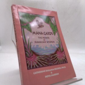 May include: A book titled Mana Cards: The Power of Hawaiian Wisdom by Catherine Kalama Becker, Ph.D. and Doya Nardin. The cover is pink with a central illustration of a bird, green leaves, and roots. The title and author names are printed in black.