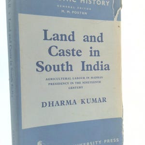 May include: A vintage book titled "Land and Caste in South India" by Dharma Kumar. The book has a light blue cover with white text and a Cambridge University Press imprint. The book is part of the Cambridge Studies in Economic History series.