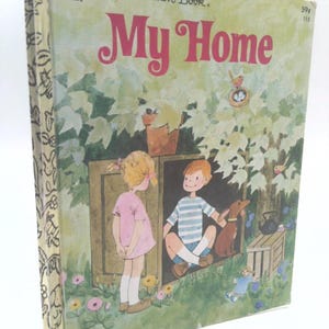 May include: A Little Golden Book titled My Home featuring a vintage illustration of a child in a pink dress standing outside a wooden box structure where another child in a blue striped shirt and a brown dog are sitting in a garden setting.