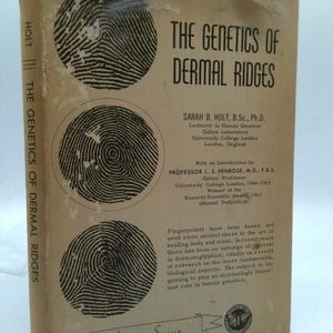 May include: A vintage book titled "The Genetics of Dermal Ridges" by Sarah B. Holt. The cover features three fingerprint images and the text "American Lecture Series". The book is beige with black text and illustrations.