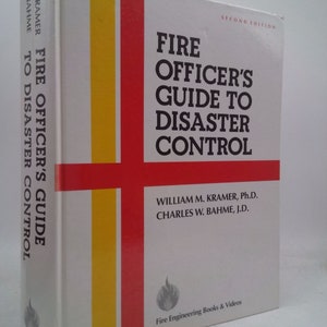 May include: A white book with a red and yellow stripe on the cover. The title is "Fire Officer's Guide to Disaster Control" with the subtitle "Second Edition". The authors are William M. Kramer, Ph.D. and Charles W. Bahme, J.D.