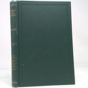 May include: A hardcover book with a dark green cover and spine. The spine features gold lettering and text. The book's cover is a solid dark green with a textured appearance. The book is leaning against a white background.