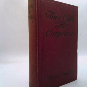 May include: A maroon hardcover book titled "They Call Me Carpenter" by Upton Sinclair. The title is in elegant script, and the book's spine shows additional text. The book has a worn appearance, suggesting it is an antique or vintage item.