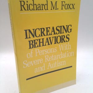 May include: A yellow softcover book titled Increasing Behaviors of Persons With Severe Retardation and Autism by Richard M. Foxx. The cover features black and white text printed on a bright yellow background with horizontal black lines.
