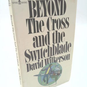 May include: A vintage paperback book titled "Beyond The Cross and the Switchblade" by David Wilkerson. The cover is off-white with large black text and a colorful illustration of a man and a church.