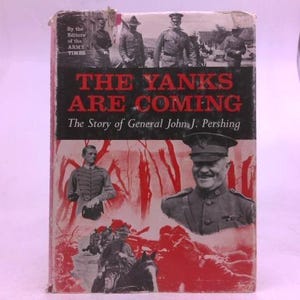 May include: A hardcover book titled The Yanks Are Coming: The Story of General John J. Pershing by the Editors of the Army Times. The cover features a black and white photograph of General Pershing and soldiers, overlaid with red graphic elements.
