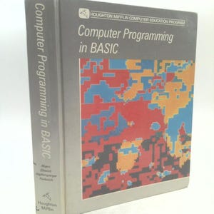 May include: A hardcover book titled "Computer Programming in BASIC" by Houghton Mifflin. The cover features a colorful abstract design in red, blue, orange, and black. The spine displays the title and author names.