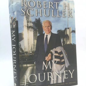 May include: A hardcover book titled "My Journey" by Robert H. Schuller. The cover features a portrait of Schuller in a suit, with a building in the background. The book's title is in large white letters.