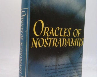 Może przedstawiać: Zabytkowa książka zatytułowana "Oracles of Nostradamus" z niebiesko-czarną okładką. Tytuł jest dużymi żółtymi literami. Na grzbiecie napis "Oracles of Nostradamus" i numer "81".